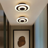 Two round coffee ceiling lights in a corridor beside framed art