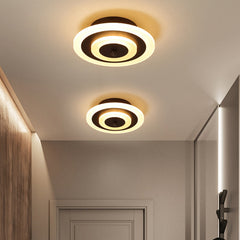 Two round coffee ceiling lights lit warm beside a hallway door
