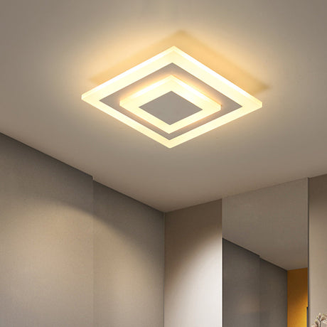 Square ceiling light lit warm in the corner of a white ceiling