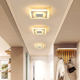 Three square ceiling lights above a hall with wall coat hooks
