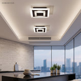 Two square ceiling lights above a kitchen bench with a city view