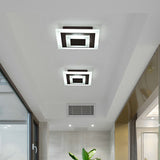 Two square ceiling lights on the ceiling of a wide bright corridor