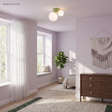 Flush mount globe light on a lilac bedroom ceiling beside tall bright windows