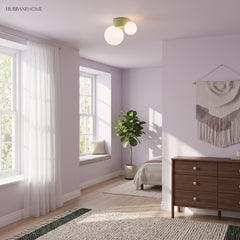 Flush mount globe light on a lilac bedroom ceiling beside tall bright windows