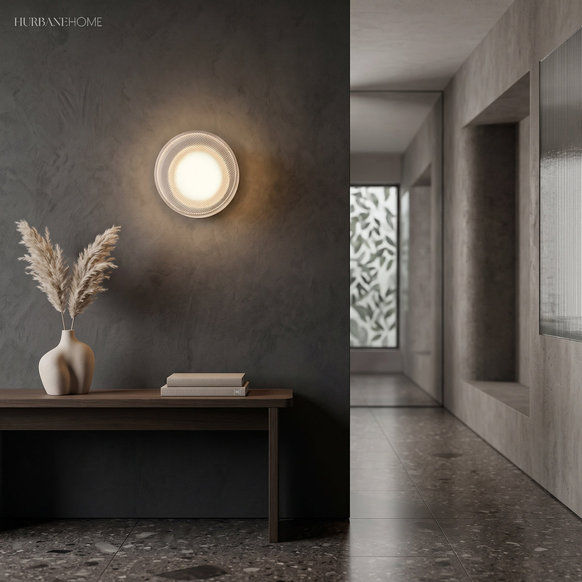 Gold ribbed wall light lit above a console table in a dark hallway