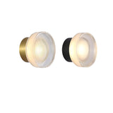 Gold and black ribbed disc wall lights side by side on a white ground
