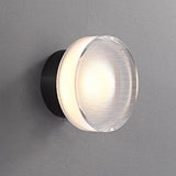 Two ribbed disc wall lights mounted on a white slatted wall
