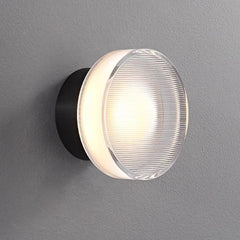 Two ribbed disc wall lights mounted on a white slatted wall