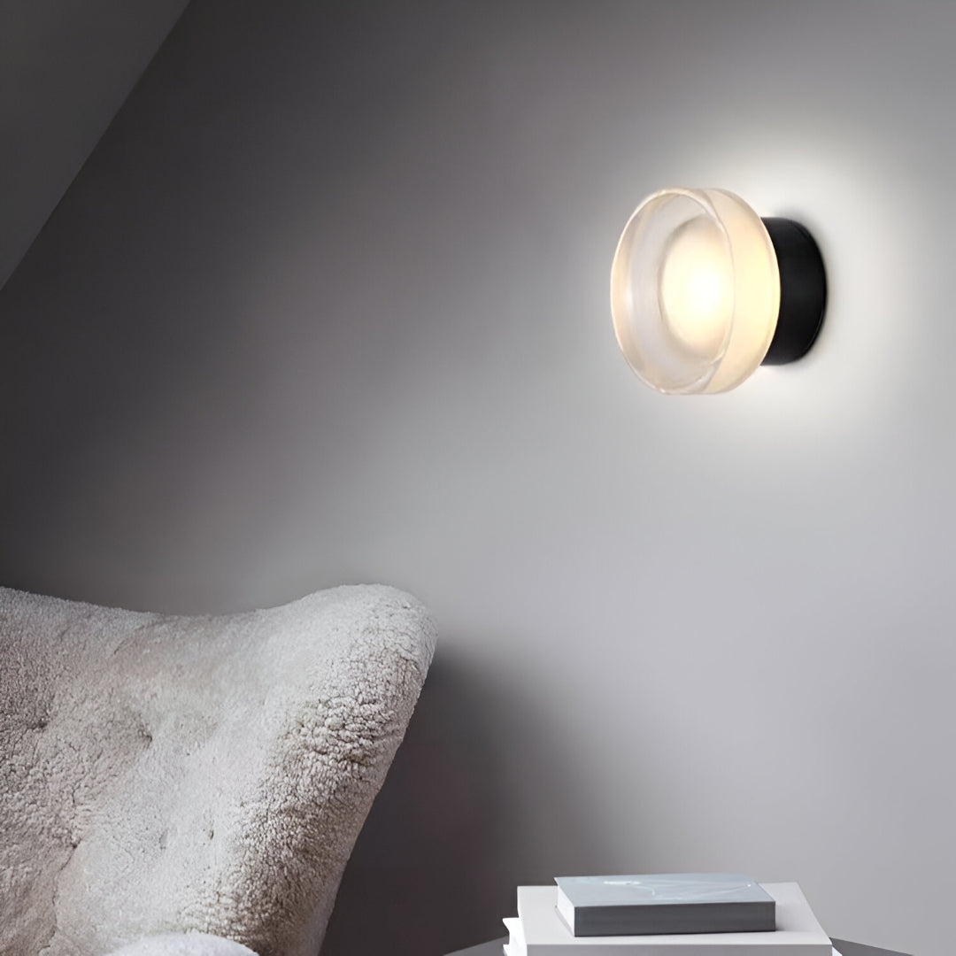 Ribbed acrylic wall lights lit above a bathroom basin and tap