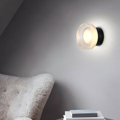 Ribbed acrylic wall lights lit above a bathroom basin and tap