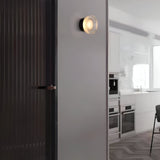 Gold ribbed wall light on a plain white wall at an angle