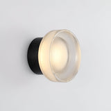 Two ribbed disc wall lights in a hallway with an arched opening