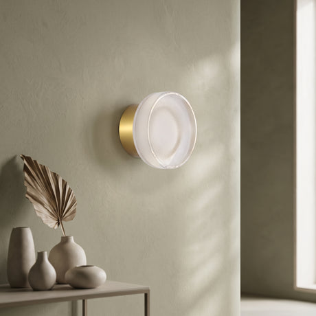 Gold ribbed acrylic wall light lit on an olive wall above vases