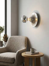 Silver disc wall lights above an armchair and side table