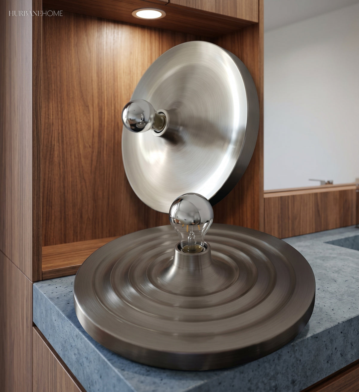 Silver disc light reflected beside a walnut and stone counter
