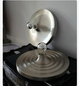 Two silver disc lights, one lit, against a dark background