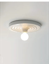 White disc ceiling light with a round opal bulb below it