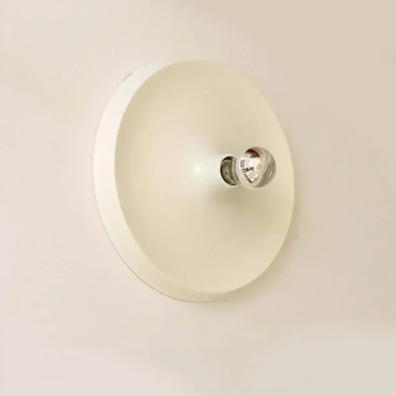 Cream disc wall light with a small bulb at the centre