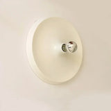 Cream disc wall light with a small bulb at the centre
