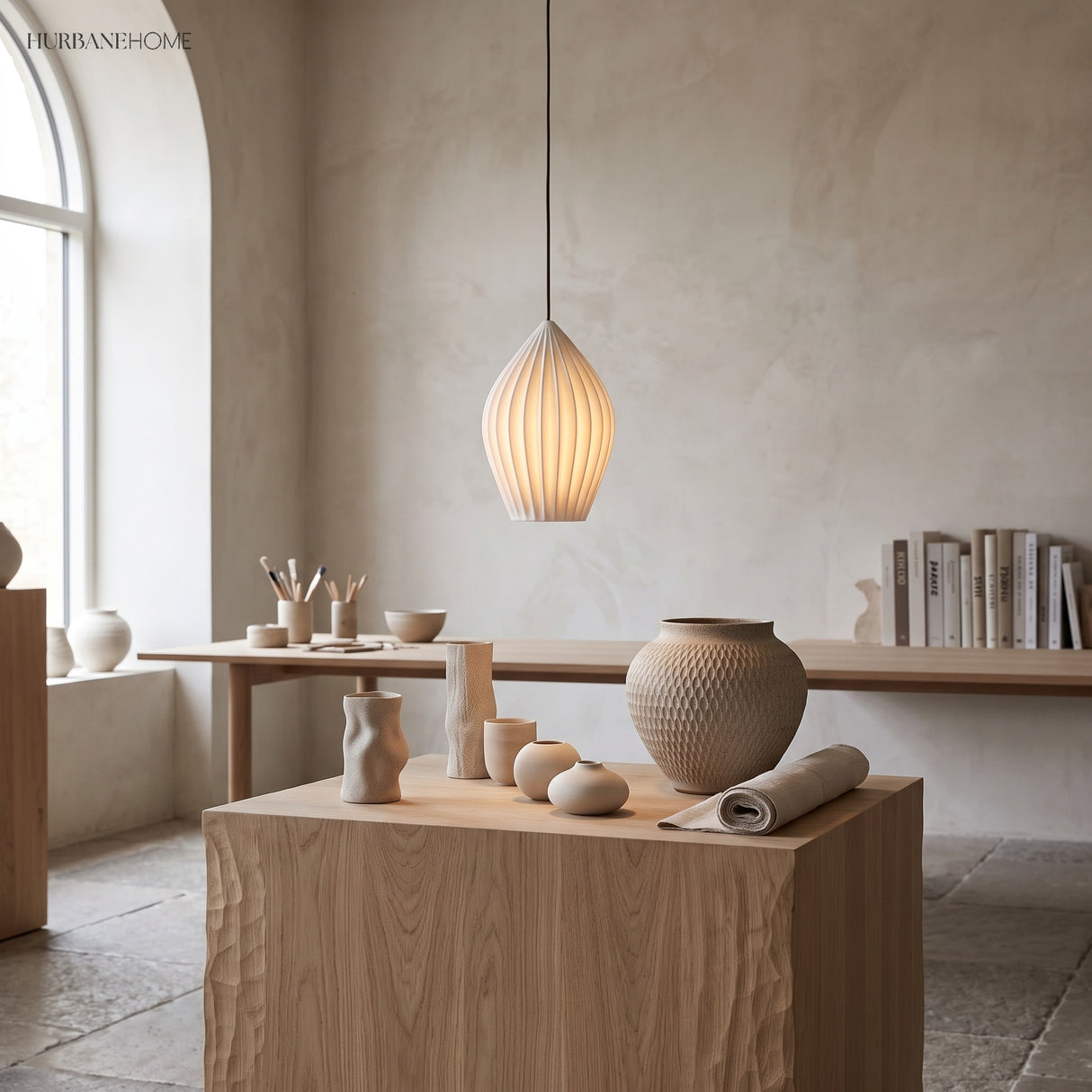 Fluted ceramic pendant lighting a pale oak island with pottery display