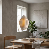 White fluted ceramic teardrop pendant above a dining table and bench