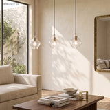 Three fluted glass pendants in a row above a light oak dining table