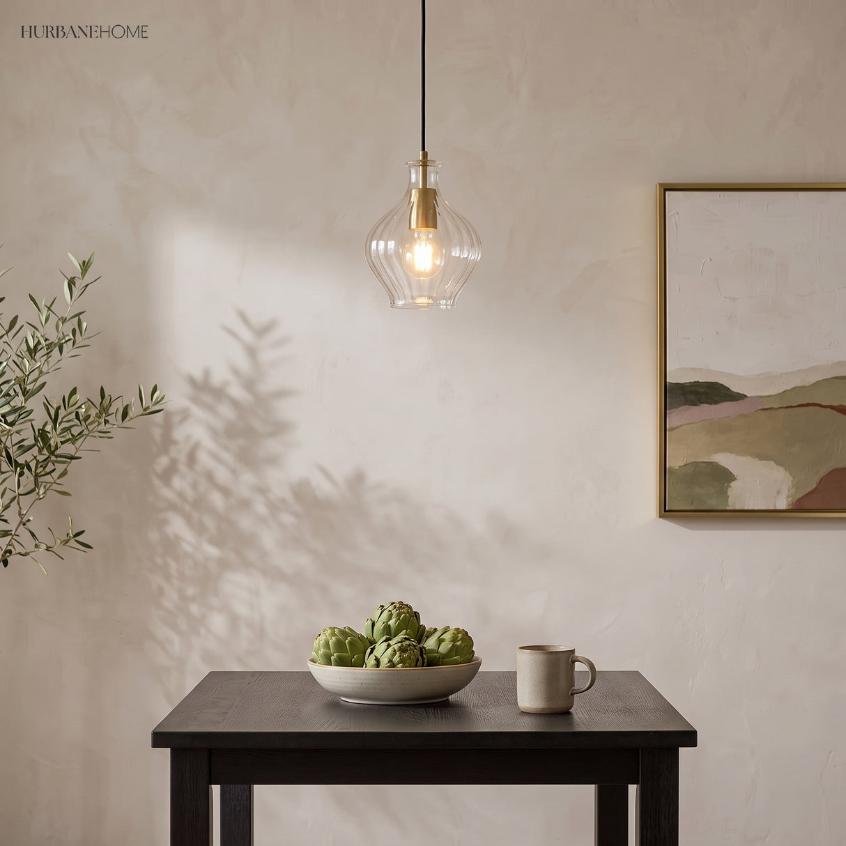 Single fluted glass pendant above a dark table against plaster walls