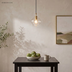 Single fluted glass pendant above a dark table against plaster walls