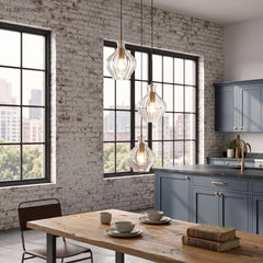 Fluted glass pendants above a kitchen island in a brick walled loft