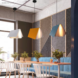 Book form pendant lights suspended above a dining table setting