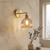 Amber lotus glass wall sconce on a textured plaster wall
