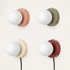Four frosted glass globe wall lamps in terracotta, olive, cream and red