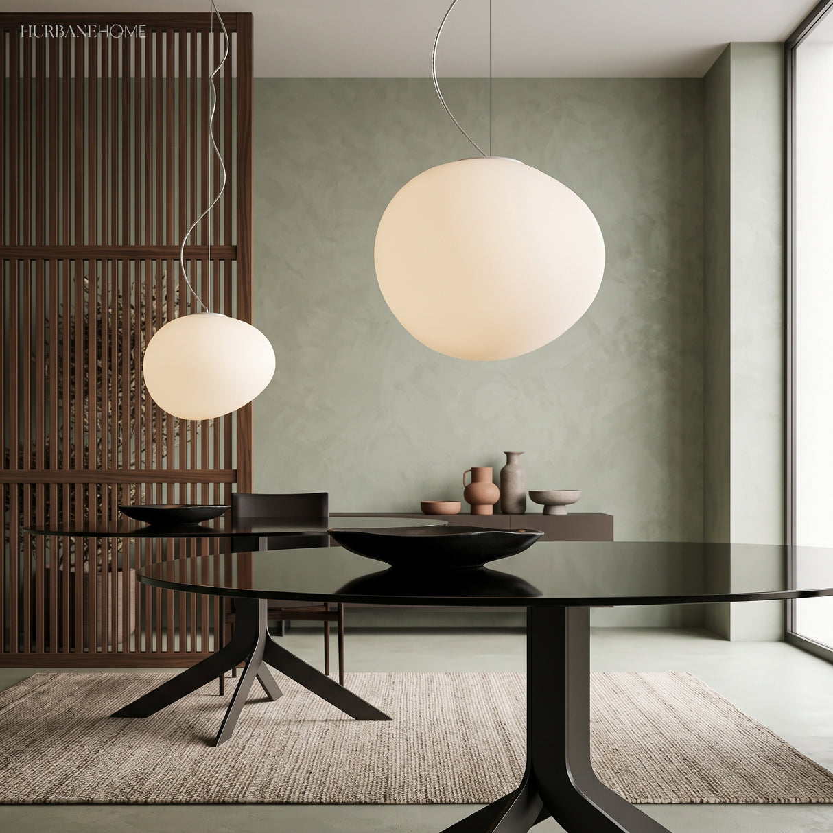 Two pebble pendants lit above a dark round dining table