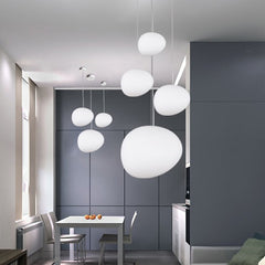Pebble pendants lit at mixed heights in a grey and white kitchen