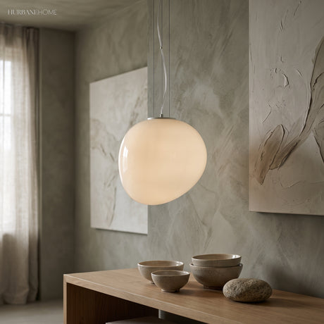 White pebble pendant lit above a sideboard holding wood bowls