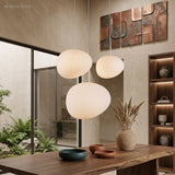 Three pebble pendants lit in a room of timber and green plants