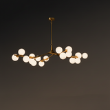 Gold branch chandelier lit against a dark background showing its spread