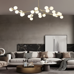 Gold branch chandelier above a neutral sofa and round coffee table