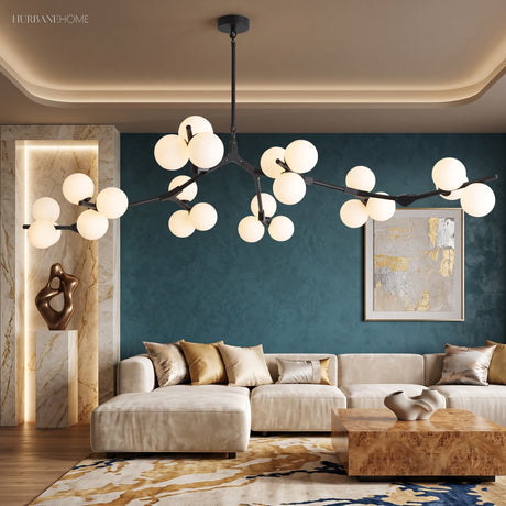 Black branch chandelier with white glass globes above a cream sofa