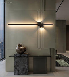 Warm linear wall sconce highlighting a minimalist interior wall