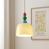 Beaded pendant hanging beside a framed flower market print on a pale wall