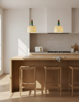 Two beaded pendants above a pale timber kitchen island with bar stools