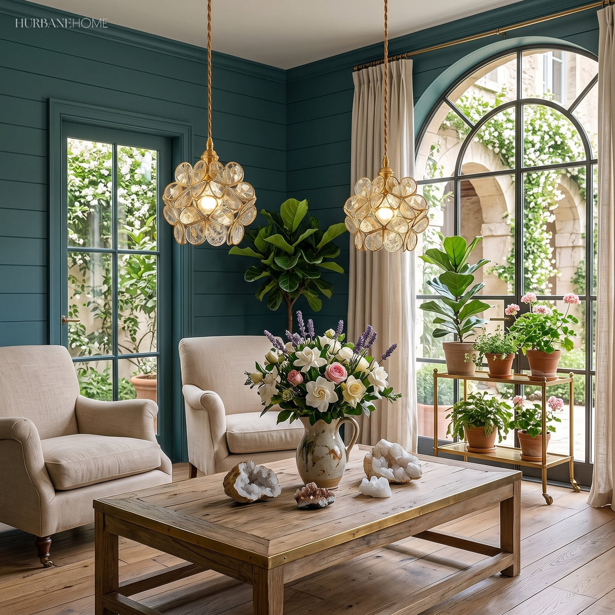 Two clear glass flower pendant lights lit above a plant-filled living room