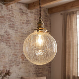 Crackle glass sphere pendant lit against exposed brick and timber beams