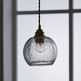 Squat crackle glass pendant in cool daylight beside a window frame