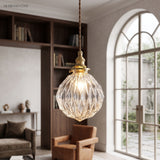 Faceted globe pendant hanging in a library beside a tall arched window