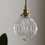 Unlit faceted glass globe showing the cut diamond pattern and brass collar