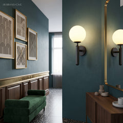 Black and gold globe sconces lit along a teal panelled hallway