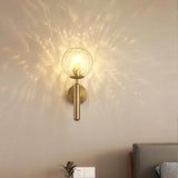 Ripple glass globe scattering points of light across a warm wall