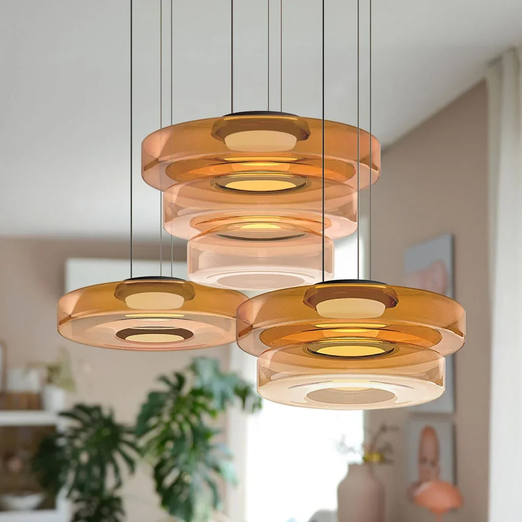 Cluster of amber mixed-layer glass pendant lights in a bright room with a plant